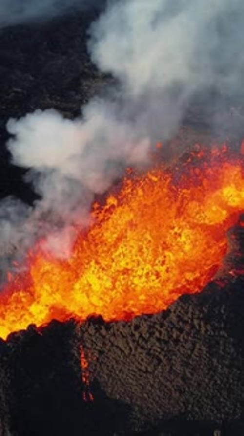 Vulkanausbruch auf vertikalem Bildschirm im Jahr 2023 Rote brennende Lava bricht in Island aus dem Boden aus
