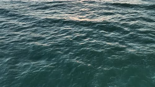Sun Reflecting on Sparkling Blue Sea Ocean at Sunset Sunrise Aerial View Slow Motion