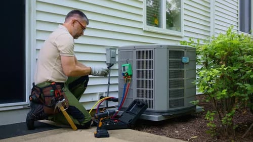 Man Performing Maintenance on an Air Conditioning Unit