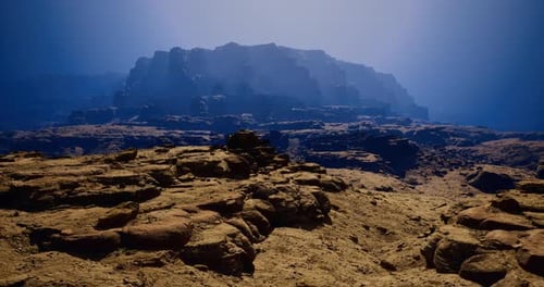 Majestic Rocky Landscape Under a Hazy Blue Sky at Dusk