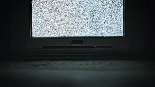 Old CRT TV Showing Static Noise in Dark Room Low Angle View
