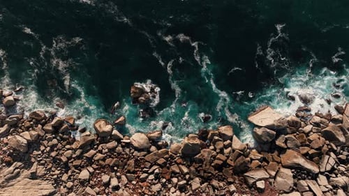 Drone View of Waves Crashing on Rocky Boulder Beach. Static Long Shot - Wide. Power, Energy Concept