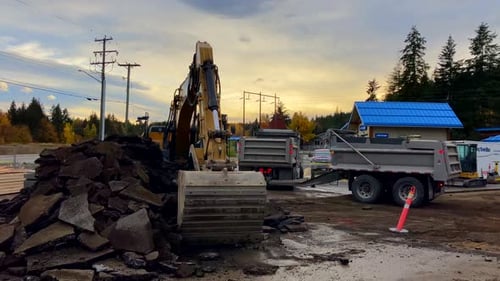Excavator Loads Construction Debris onto Truck