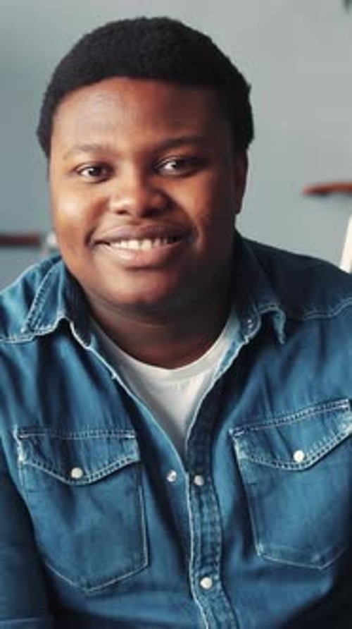 Young Adult Smiling in a Denim Shirt