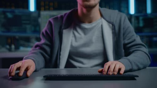 Man Typing on Keyboard in Dark Tech Environment