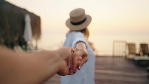 Une femme heureuse conduisant son petit ami ou son mari en mer après un coup de feu, tenez la main, voyagez en mer ou en océan