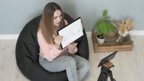 A math teacher conducts an online lesson with high school students via a tablet.