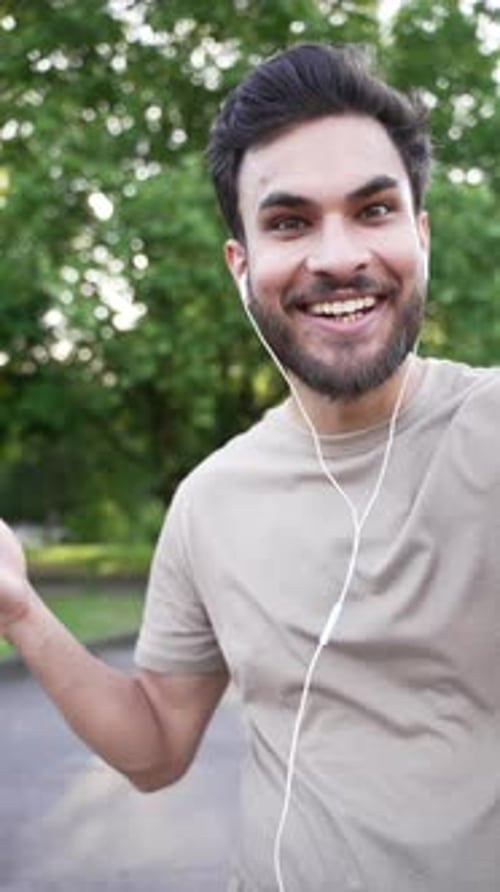Man Waving and Talking in Urban Park Setting