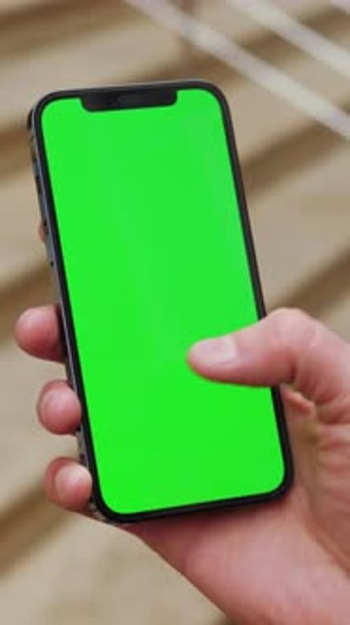 Closeup Image of Hand Holding Device Detailed View of Hand Clutching Phone with Green Screen and