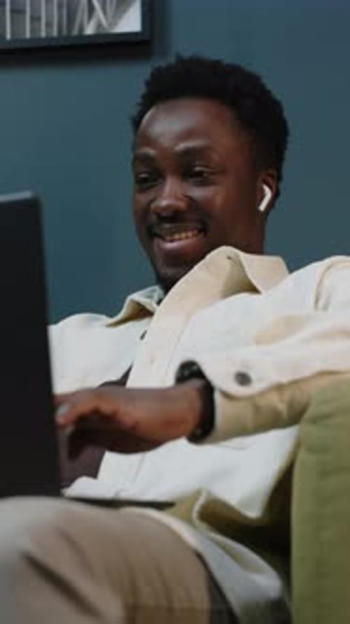 Smiling Man Working on Laptop at Home