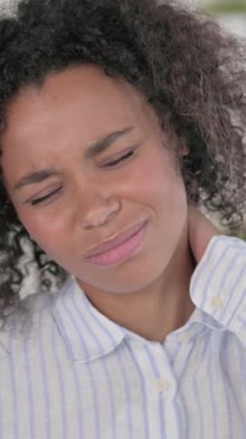 Woman Rubbing Her Neck in Discomfort Indoors