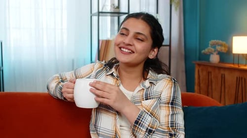 Woman Drinking Coffee on Couch at Home
