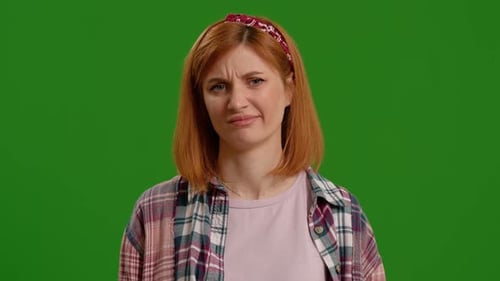 Woman expressing hesitation feels puzzled and unamused on isolated on green screen background.