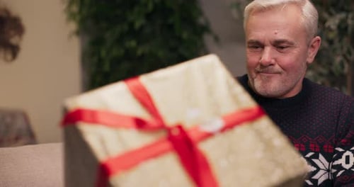 Man Unwraps Present with Teenager Indoors
