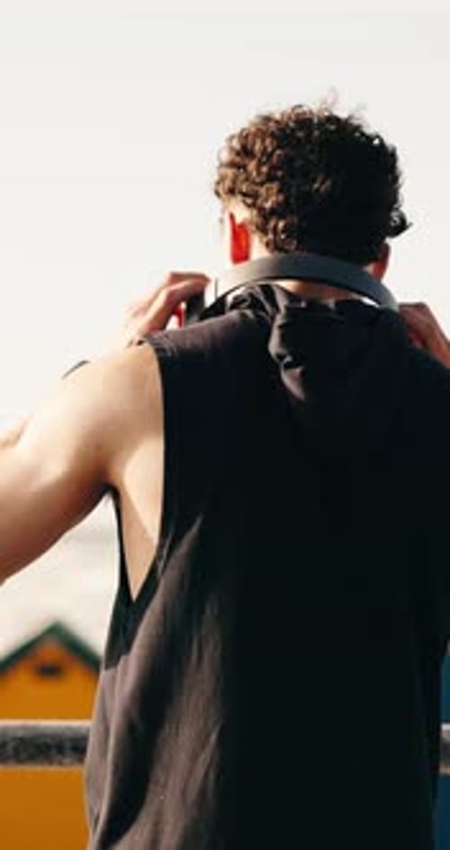 Fitness, headphones and back of man in city for exercise, workout and rest after training