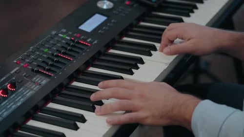 primer plano de las manos tocando un teclado digital, centrándose en los controles y las teclas del instrumento