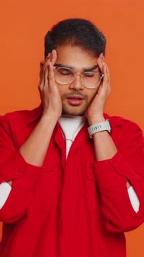 Thoughtful young adult with hands on face