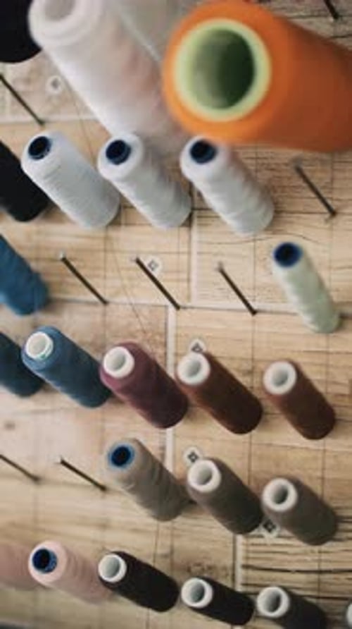 Colorful Spools of Thread on a Wooden Board