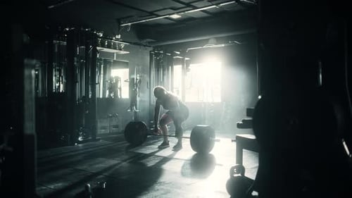 Professional Female Powerlifter Lifting Heavy Weights and Dropping Them in a Dark Gym. Portrait of