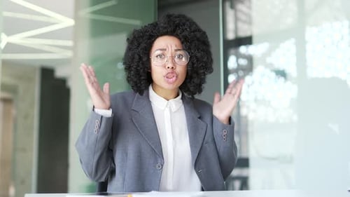 Webcam view. Angry african american businesswoman in a suit arguing talking on a video call sitting