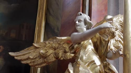 Statue of an angel with wings in a gilded robe. Roman Catholic church of St. Anne in Warsaw Poland