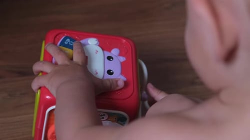 Infant Interacts With Interactive Toy at Home