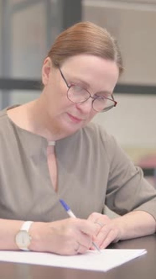 Old Businesswoman Reading Documents at Work