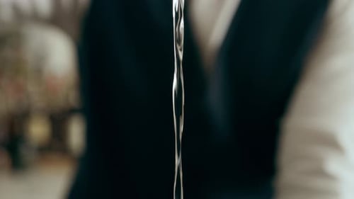 Bartender creates a classic martini cocktail in a trendy upscale bar close up