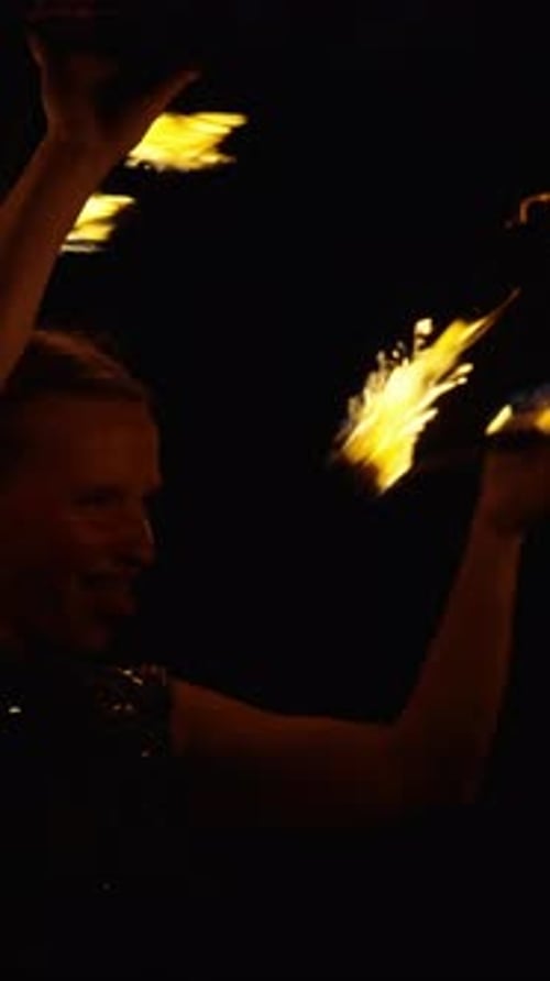Dynamic Fire Dancer Performing Energetic Nighttime Routine with Blazing Flames and Expressive Arm