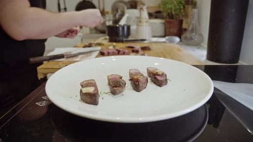 Decorating steak dish on a white plate with spices and organic sauce.. Steak cooking.