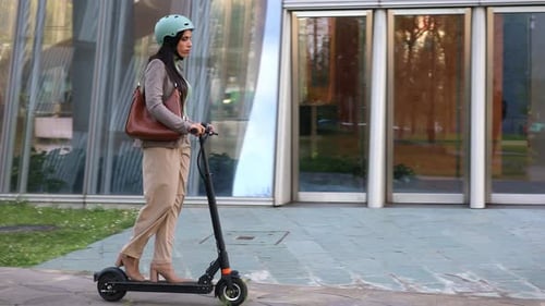 Businesswoman Commuting to Work on Electric Scooter