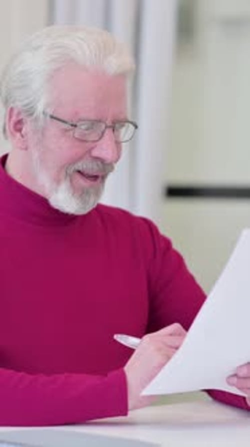 Senior Man Reviewing Documents and Giving Thumbs Up