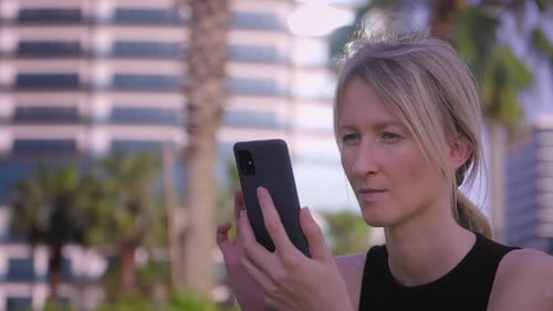 Woman texting on smartphone working in park