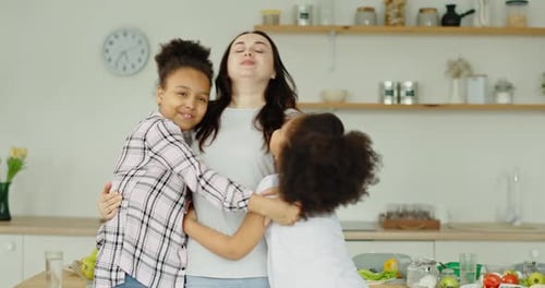 Loving Mother Embraced by Two Young Daughters