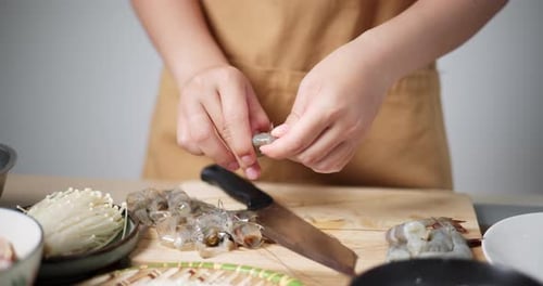 Person Prepares Shrimp at Kitchen Counter