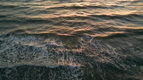 Tropical golden sunset over ocean water slow motion aerial view. Sun setting reflection on seascape.