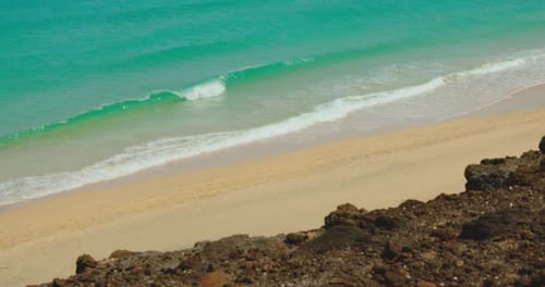 Empty white fine sand beach. Crystal clear ocean waters. Rocky cliffs on shoreline. Travel relax con