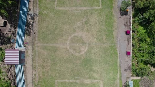 Aerial View of a Remote Soccer Field Surrounded by Dense Tropical Forest