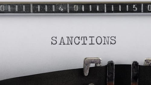 Typing the Word Sanctions on White Paper
