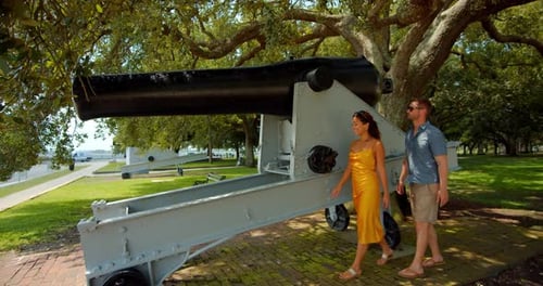 Couple strolling past historic cannons in picturesque charlotte park