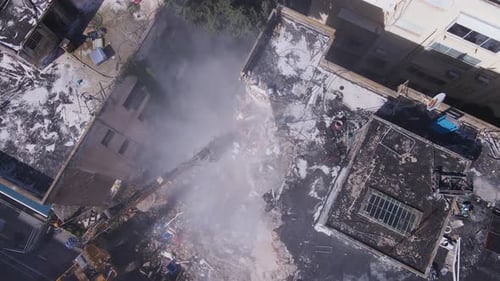 Drone top down pan above building demolition with heavy at construction site