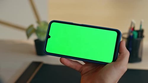 Man Holding Greenscreen Smartphone in Office Closeup Manager Using Mockup Cell
