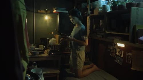 Woman Uses Her Phone in Her Dark Apartment