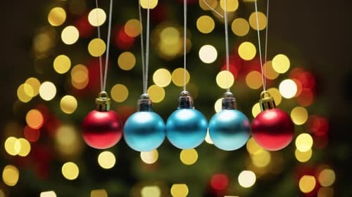 Christmas Ornaments Swinging Against Bokeh Background