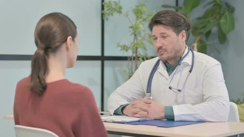 Male Doctor Talking with Patient in Clinic