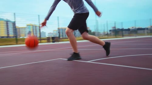 Young Adult Dribbles and Shoots Basketball on Urban Court