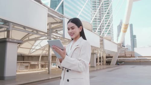 Portrait of young beautiful businesswoman using tablet in modern city