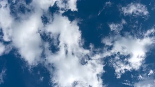 Ciel bleu avec des nuages en mouvement.