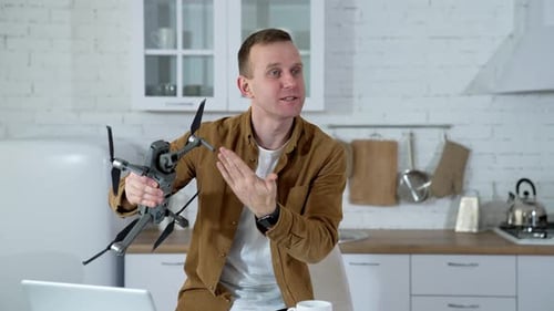 Mann zu Hause mit Drohne. Junger Mann spielt zu Hause mit Drohne