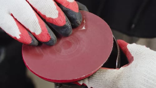 Worker Changing Sanding Disc on Power Tool